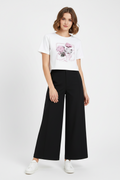 Mannequin wearing a white t-shirt with a graphic design and black wide-leg pants on a white background